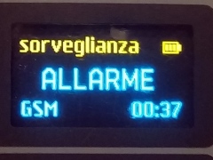 Una microspia GSM e'  in funzione  e sul display  si legge in grande l ascritta ALLARME , sotto il tipo di segnale ( GSM ) e in basso a sinistra l'orario 